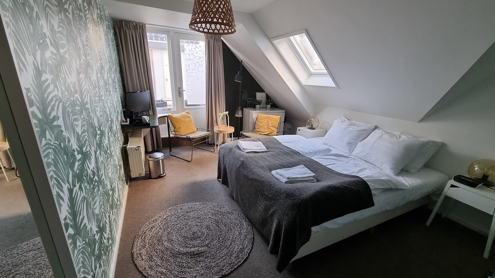 Gezellige zolderkamer met tweepersoonsbed en botanisch behang in Giethoorn Old Art Hotel
