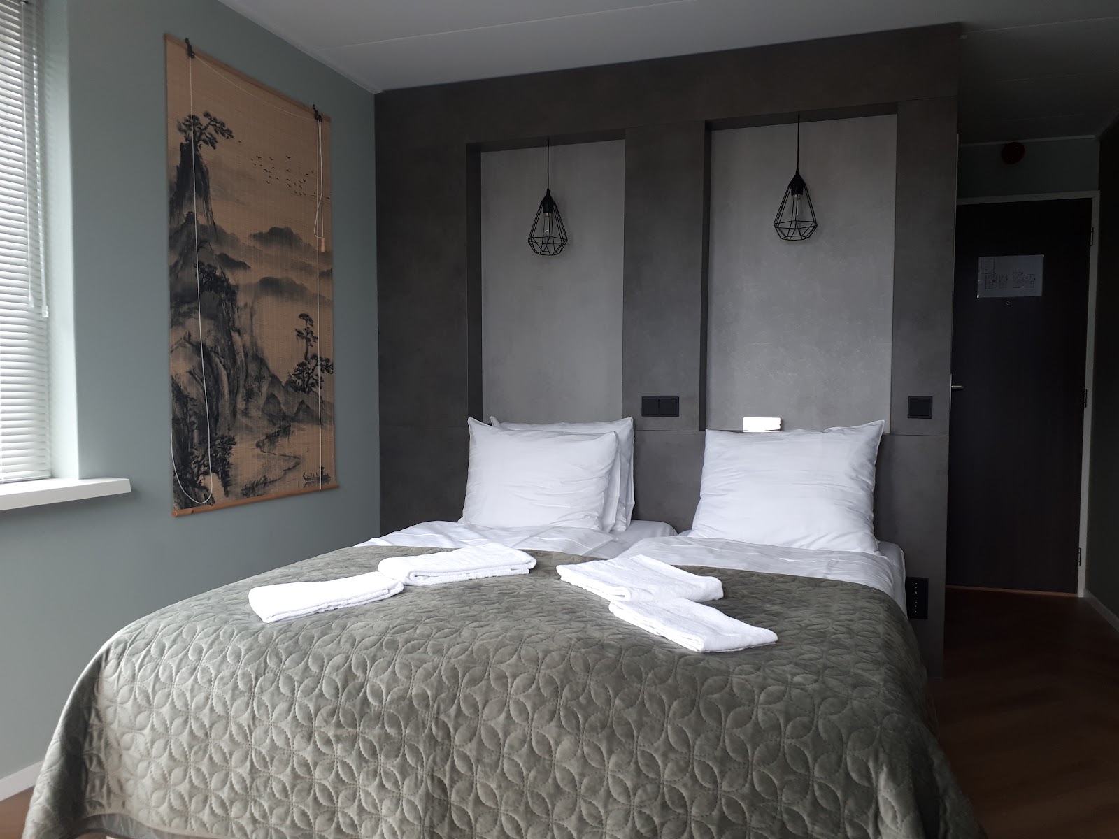 Moderne hotelkamer met tweepersoonsbed en Aziatische wandkunst
